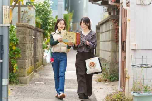 two women walking down a street looking at a map at KAMAKURA DEL COSTA in Kamakura