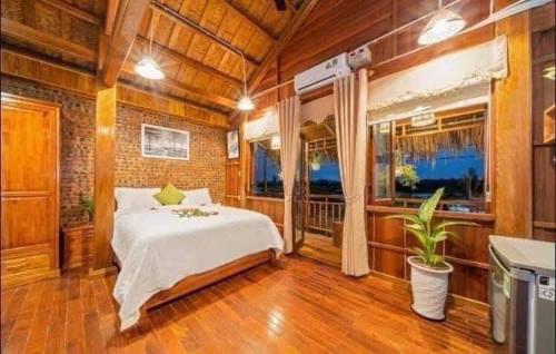 a bedroom with a white bed and a window at Family Tan Thanh in Tân Thành (1)