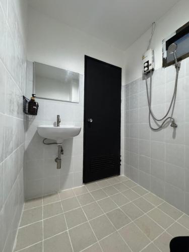 a bathroom with a black door and a sink at Chapter 26 in Patong Beach
