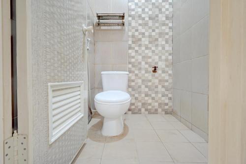 Un baño con un inodoro blanco en una habitación. en OYO 95041 Griya Indah Homestay, en Djetak