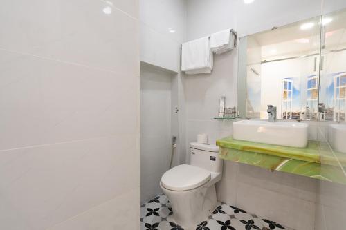 Lucky Star Hotel - Lê Thị Riêng في مدينة هوشي منه: حمام أبيض مع مرحاض ومغسلة