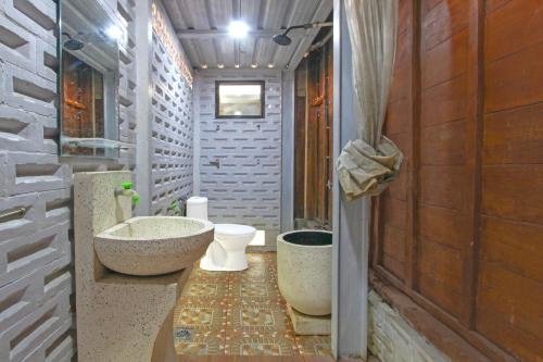 uma casa de banho com uma banheira e um WC. em OYO 95018 Anggrek Homestay Jogja Syariah em Timuran