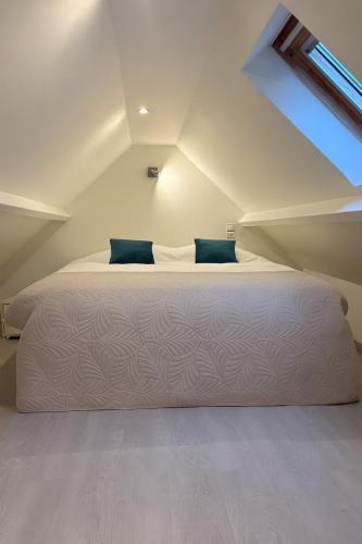 a bedroom with a bed in a attic at Le cocon bleu, duplex cosy et lumineux in Précy-sur-Oise