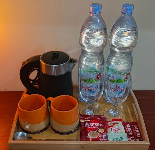 un vassoio con due bottiglie d'acqua e due tazze di The Cat And The Kraken Paliton Jacuzzi Suites with Solar and Starlink a Siquijor