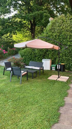 a picnic table and an umbrella in the grass at Il rifugio del sole in Barasso