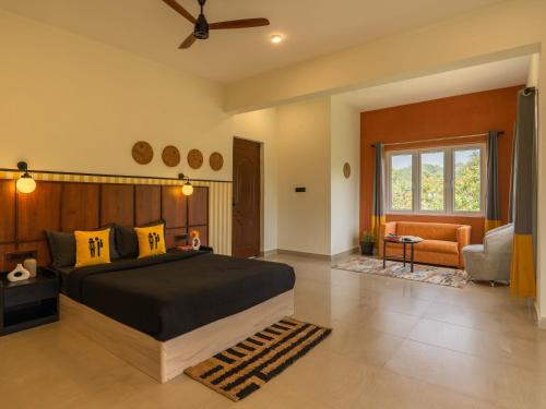 ein Schlafzimmer mit großem Bett und ein Wohnzimmer in der Unterkunft The Hosteller Bam Coorg in Madikeri