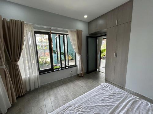a bedroom with a bed and large windows at Nghi Homestay Phan Rang in Bắc Sớn