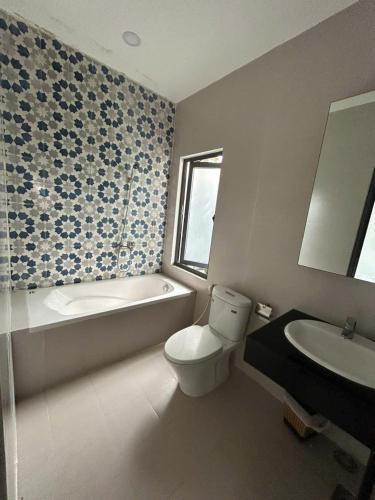 a bathroom with a toilet and a tub and a sink at Nghi Homestay Phan Rang in Bắc Sớn