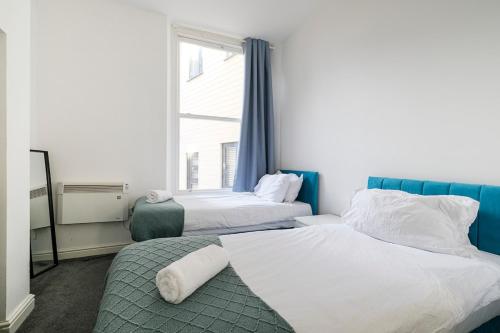 Un dormitorio con dos camas y una ventana. en 1 Bedroom Apartment, Free Parking, WiFi, en Gloucester