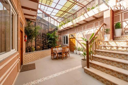 una veranda con tavolo e sedie in un edificio di StayVista at Arches and Aura with Terrace, Meals a Mathura