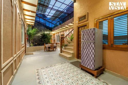 un corridoio vuoto con frigorifero in un edificio di StayVista at Arches and Aura with Terrace, Meals a Mathura