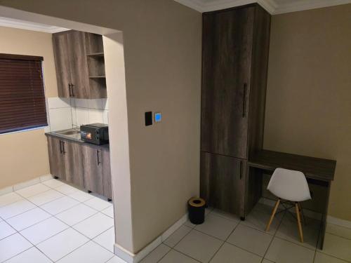 a kitchen with a counter and a chair in a room at La Majestic Guest Lodge in Centurion
