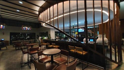 een restaurant met een bar met stoelen en tafels bij Zuri Marula Luxe in Midrand