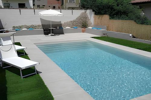 een zwembad met een stoel en een parasol bij Ginetta 2 - Prosecco Hills Holidays in Miane