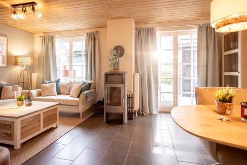 salon z kanapą i kominkiem w obiekcie Seestern Greetsiel für bis zu 4 Personen - Haustiere herzlich willkommen, direkt am Hafen, Whirlpool, Kaminofen w mieście Greetsiel