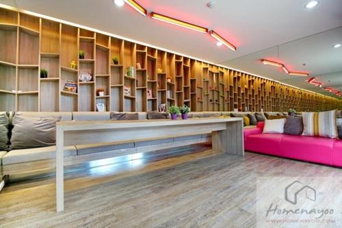 een lobby met een bank, een tafel en planken bij Plum condo Bang-yai station in Nonthaburi