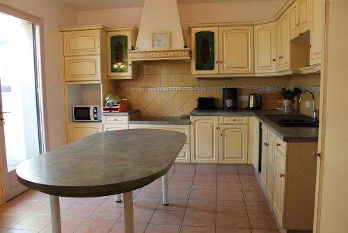 朗德蒙特Gîte Isatis的厨房里有白色的橱柜和一张桌子