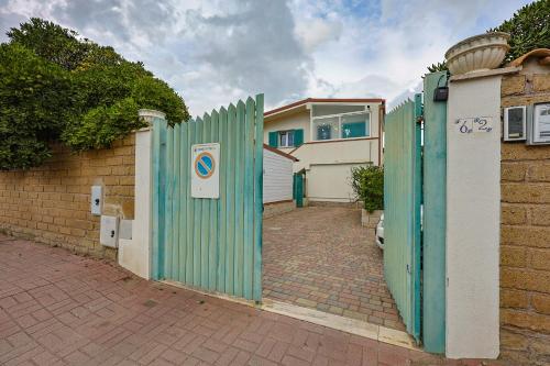 a green fence in front of a house at Azure Oasis with parking near the airport & beach in Focene