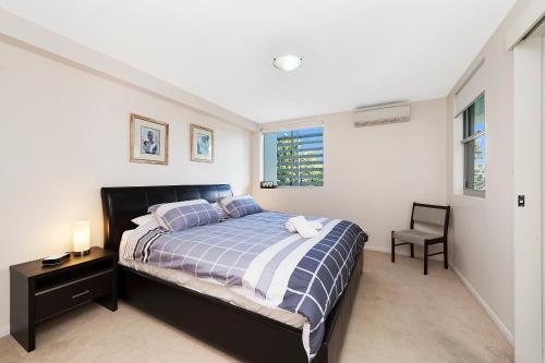 1 dormitorio con 1 cama y 1 silla en Keith's Sister, 1 of the 4 most popular units on Bribie, en Bongaree