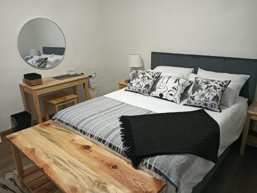 ein Bett mit einer schwarzen und weißen Decke und einem Spiegel in der Unterkunft Storms River Peak Accommodation in Stormsrivier
