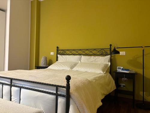 ein Schlafzimmer mit einem Bett mit gelber Wand in der Unterkunft AGAVE Suite in San Ligorio