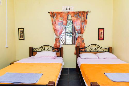 two beds in a room with a window at EKO Holiday Homes, Lake Chala in Taveta