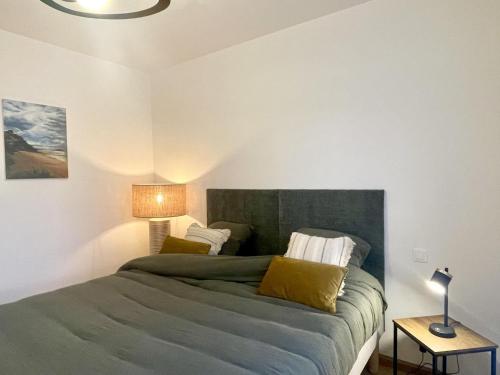 a bedroom with a bed with a green headboard at Loguel an placen in Saint-Laurent