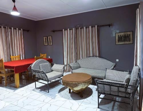 a living room with a couch and chairs and a table at EKO Holiday Homes, Lake Chala in Taveta