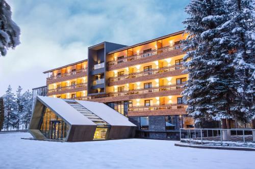 a hotel in the snow with a building at Bakuriani Inn in Bakuriani