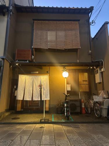a building with a window with curtains on it at Gion Kyoto Miyagawacyo Guesthouse HANAKANZASHI in Kyoto