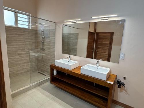 a bathroom with two sinks and a shower at Lakaz Mapou - Magnifiques Appartements rénovés de 3 chambres et 2 salles de bains in Rivière Noire