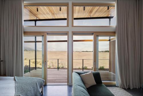 a bedroom with a bed and a large glass door at Studio on Forktree – Modern Coastal Retreat in Carrickalinga