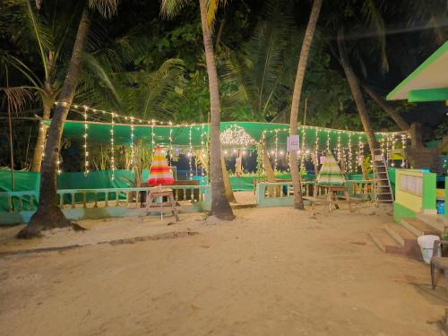a beach with palm trees and christmas lights at Oceanview Nohas Guesthouse Arambol in Arambol