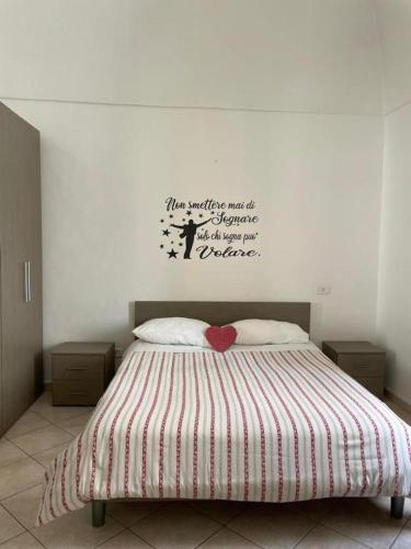 a bedroom with a bed with a quote on the wall at dimora princ di napoli 14 in Polignano a Mare