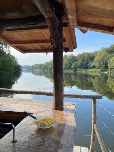 una ciotola di cibo appoggiata su un tavolo di legno su un fiume di Chalet sur l'eau a Brissarthe