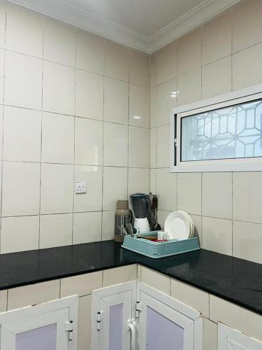 a kitchen with white tiled walls and a counter top at Vuga Town House in Zanzibar City