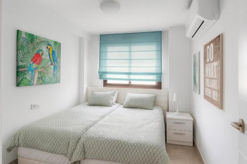 a white bedroom with a bed and a window at 3 bedroom, two-level, morden apartment in Orihuela Costa