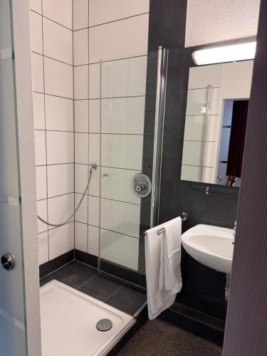 a bathroom with a shower and a sink at Hotel Restaurant Waldschlößchen in Neheim-Hüsten