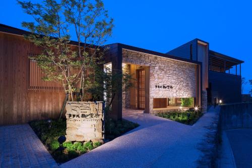 a house with a stone facade at night at SEKIYA RESORT Terrace Midoubaru in Beppu