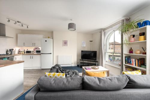 a living room with a couch and a kitchen at Air Maison - St Jude's View in Portsmouth