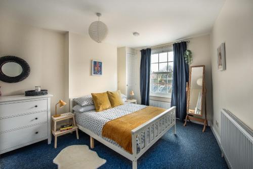 a bedroom with a bed and a dresser and a window at Air Maison - St Jude's View in Portsmouth