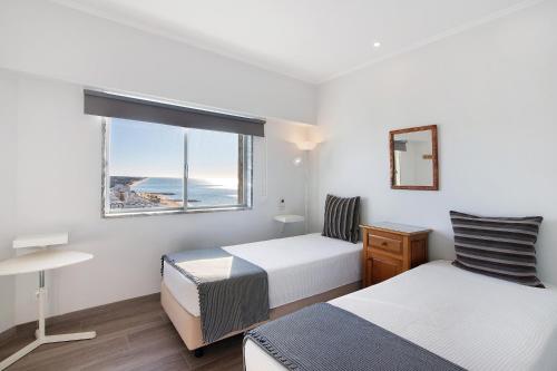 Una habitación de hotel con dos camas y una ventana. en Delmar, en Cavacos
