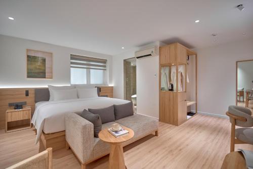 a bedroom with a bed and a couch at Amaya Saigon Boutique Hotel in Ho Chi Minh City