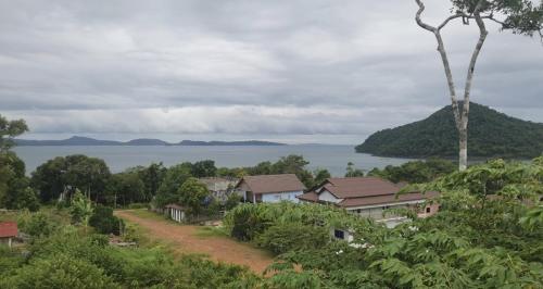 a group of houses on a hill next to the water at Big Head Bungalows in Koh Rong Sanloem