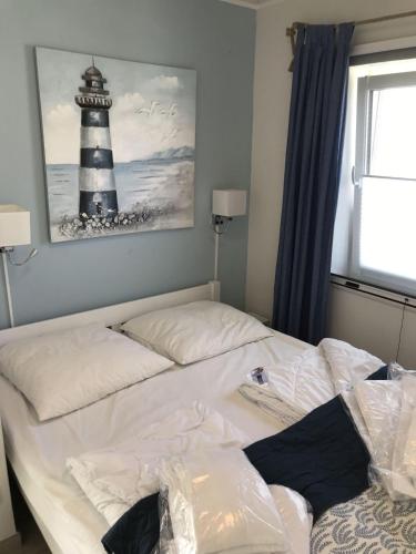 a bed in a room with a lighthouse on the wall at Strandhaus-Appartment-Rauchschwalbe in Fehmarnsund