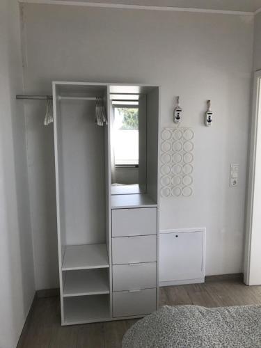 a white closet with a mirror in a room at Strandhaus Appartement - Seeschwalbe OG in Fehmarnsund