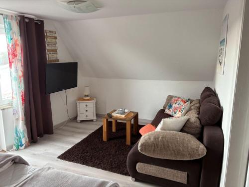 un soggiorno con un divano e una poltrona di Golfhues-Simone-Ferienwohnung-Suedbalkon a Wulfen auf Fehmarn