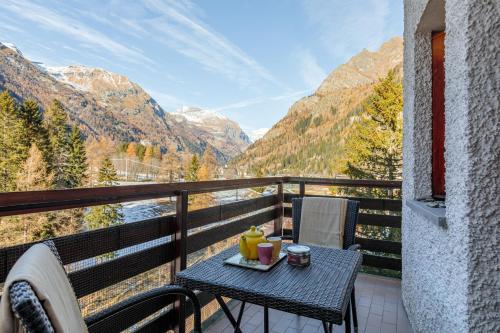 uma mesa numa varanda com vista para as montanhas em Monterosa Elite Lyshaus Luxury Mountain View em Gressoney-Saint-Jean