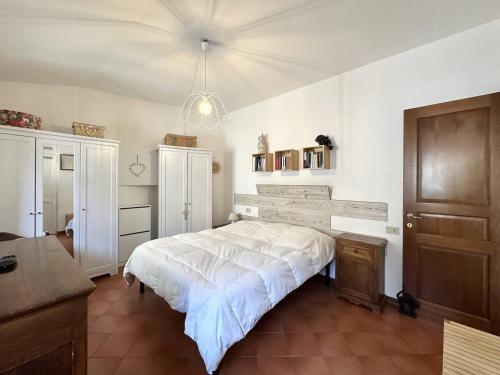 a bedroom with a large white bed and a chandelier at La terrazza su Assisi in Assisi