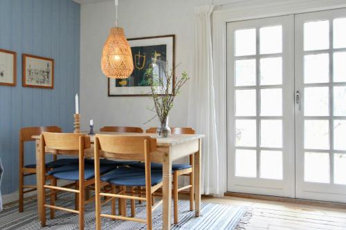 Traditional Swedish House In The Forest في ألمهولت: غرفة طعام مع طاولة وكراسي وثريا